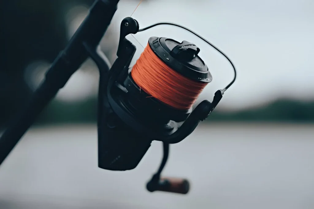 Close up shot of a fishing reel with orange braided line