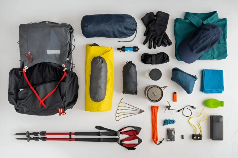 Flat lay of essential gear titled What to Bring on a Hiking Trip, including a backpack, gloves, trekking poles, clothes, cooking gear, and accessories.