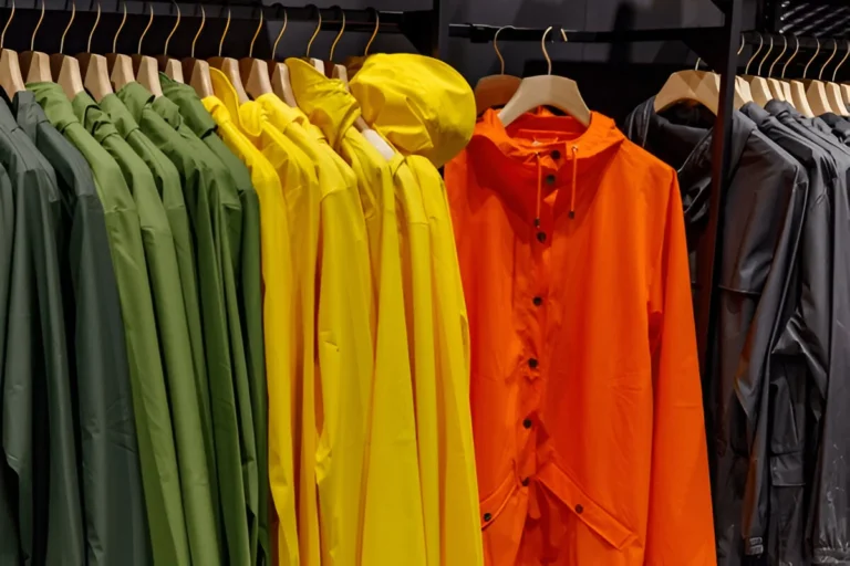 A vibrant display of colorful rain jackets neatly arranged on hangers — showcasing the best rain jackets for women.