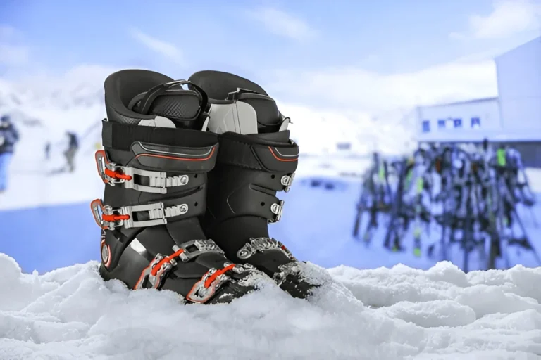 Pair of black ski boots with red and silver buckles resting on snow, ideal for showcasing the *Best Ski Boots for Wide Feet* in winter conditions.