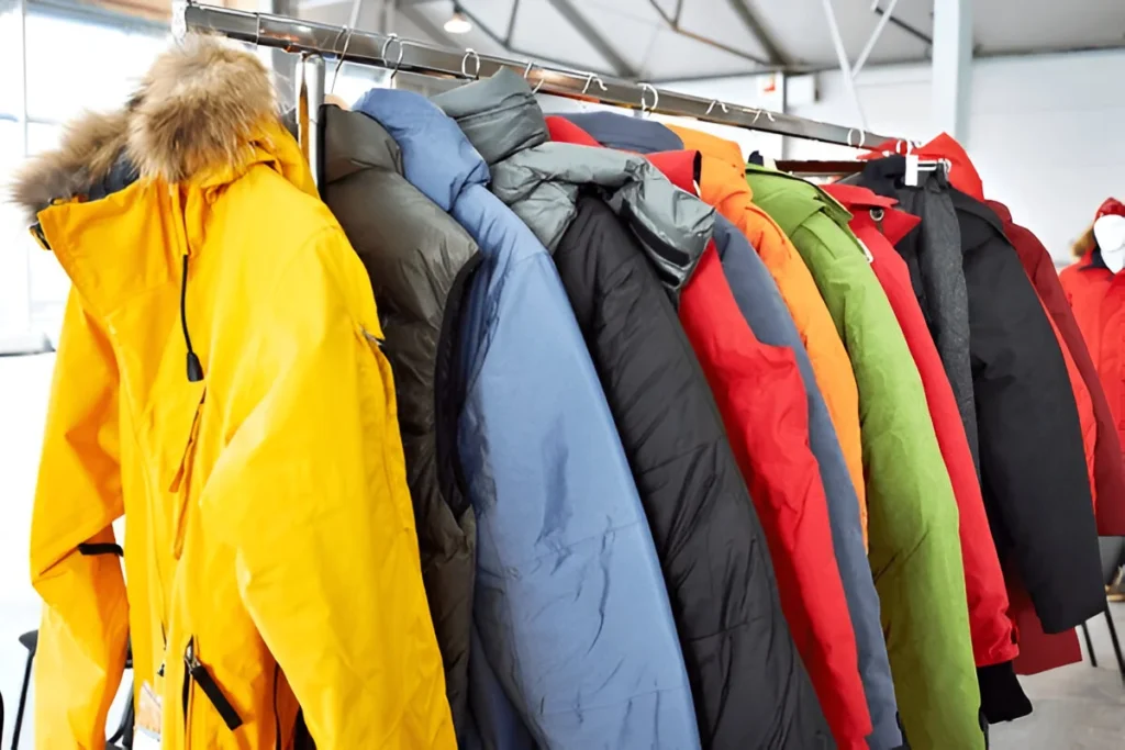 Colorful winter coats hanging on a rack in a store, showcasing a wide selection of the Best Ski Jackets for Men.
