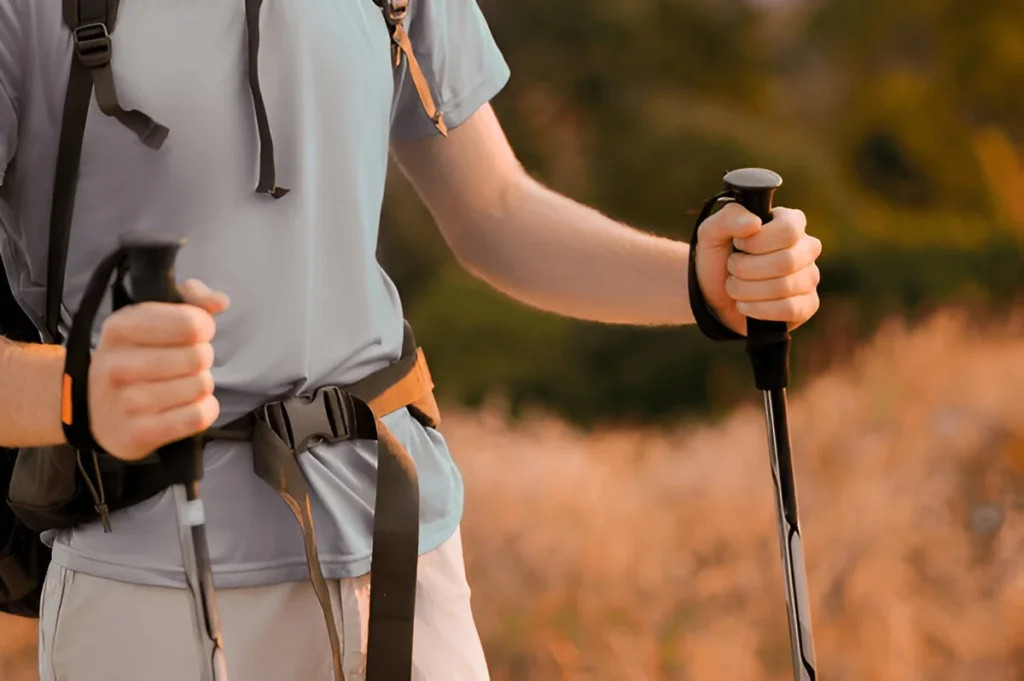 A picture of a hiker with walking sticks in hands