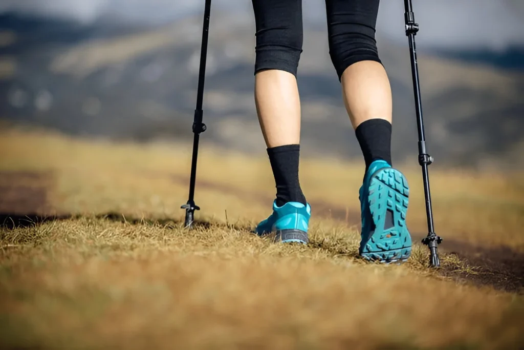 Fitness woman legs walking on high altitude grassland mountain road