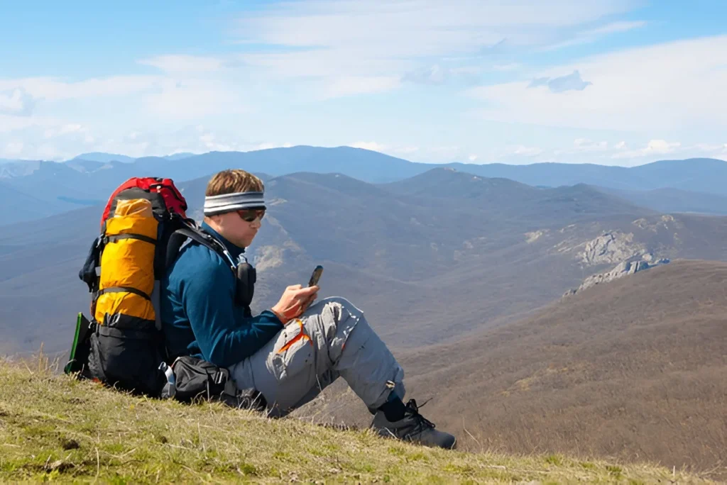Hiker using mobile device in mountains