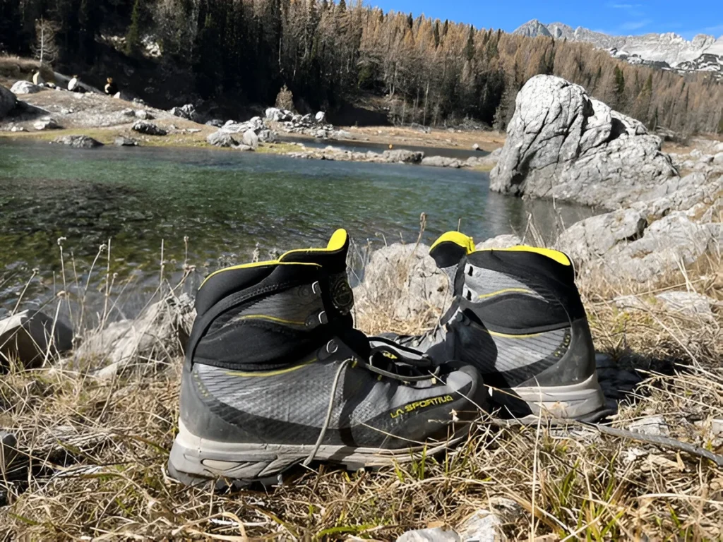 La Sportiva boots resting beside a mountain lake, showcasing the rugged design of some of the best hiking boots for alpine terrain.