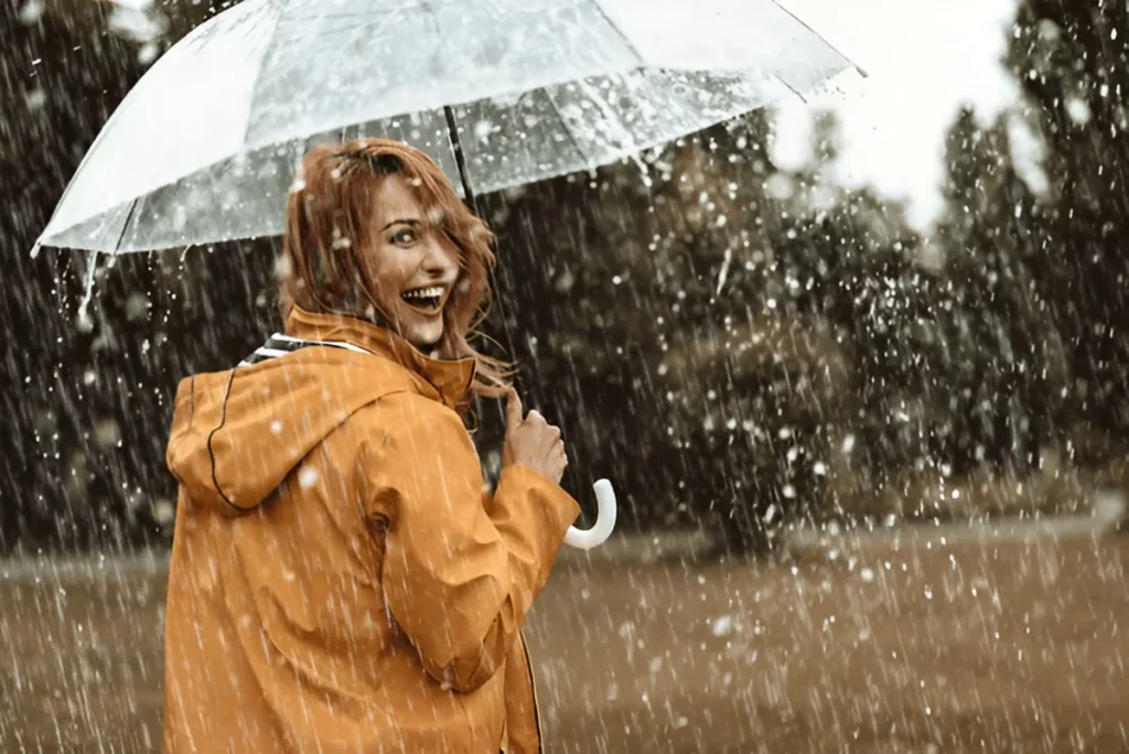 Cheerful pretty girl holding umbrella while strolling outside