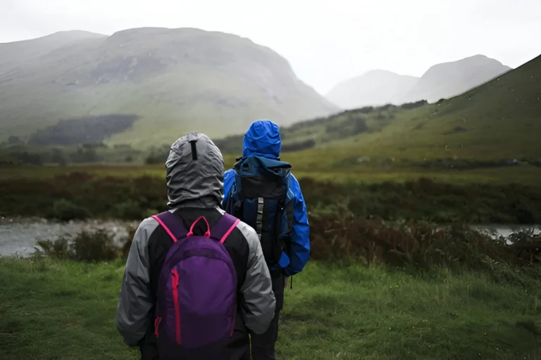 Couple trekking through the best rain jackets for men in the Highlands