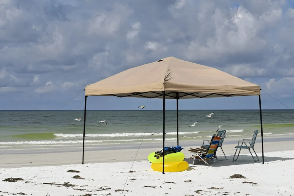A beach setup under one of the best canopy tents offers shade, comfort, and protection for a relaxing seaside day.
