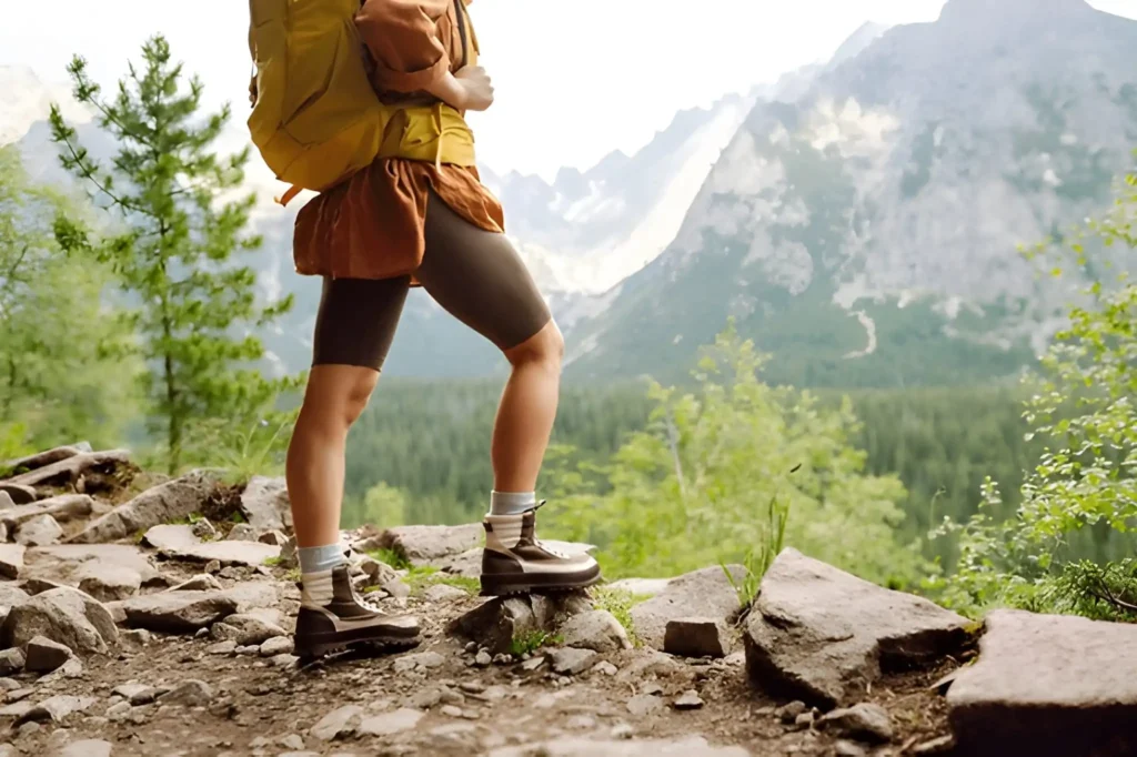 Woman standing on a rocky mountain trail wearing sturdy boots, highlighting the Best Hiking Boots for Women.